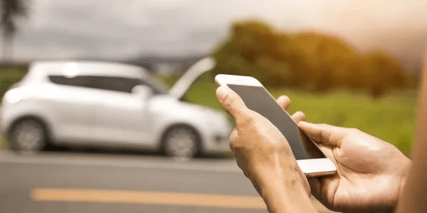 Broken down car and person on phone